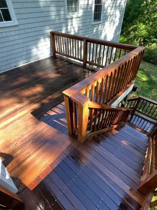 Freshly finished hardwood deck with a matching wood railing and stairs