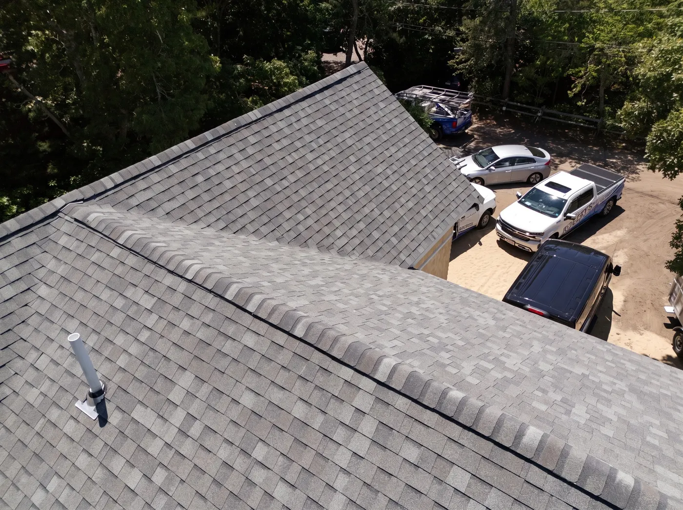 Close drone view of new architectural shingles along a roof ridge