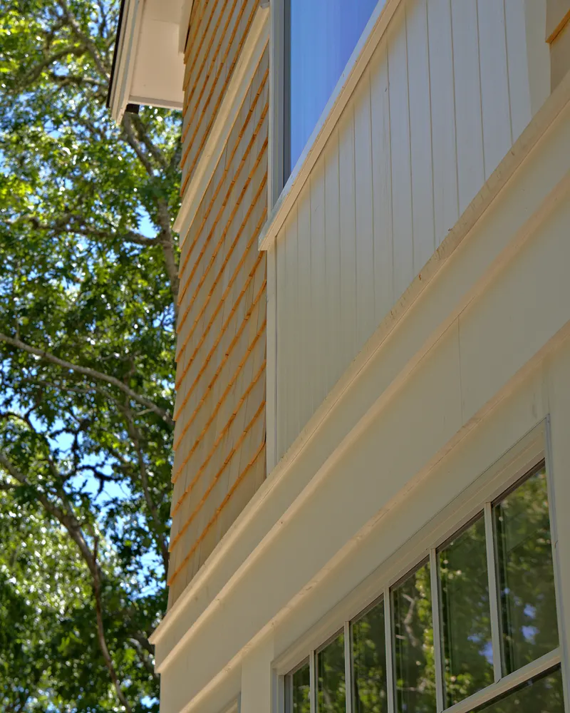 Cedar shingles meeting white trim and board siding